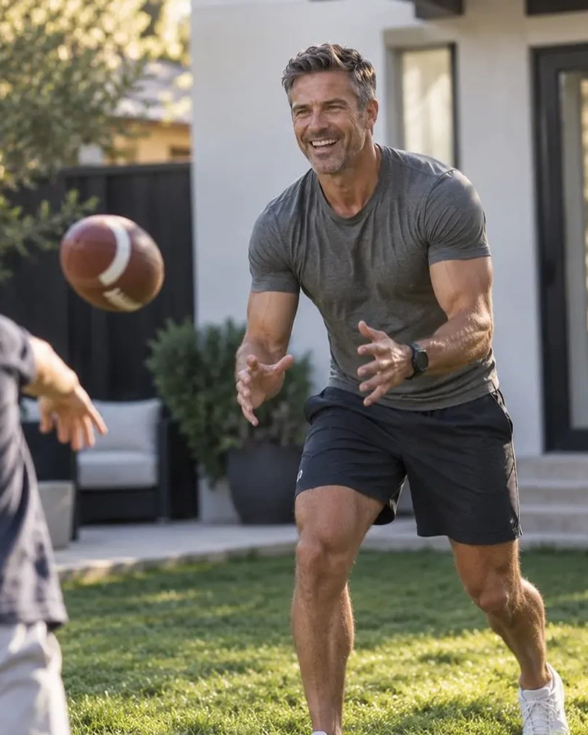 Strong, energetic father playing catch with his son in the backyard
